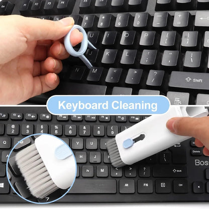 Keyboard cleaning tool being used on a black keyboard with a close-up of the brush.