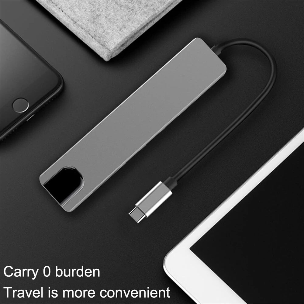 USB-C hub on a dark surface with smartphone and tablet